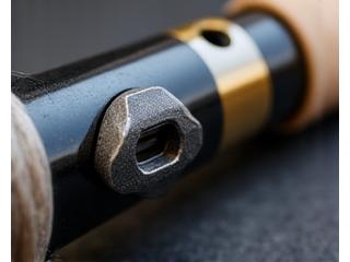 Close-up of a custom-machined reel seat made from polished aluminum